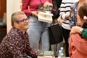 Na zdjęciu Marcin Meller podpisuje książki.