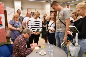 Na zdjęciu Marcin Meller podpisuje książki.