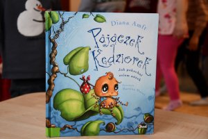 Na zdjęciu powadzaca zajęcia bibliotekarka z dziećmi.