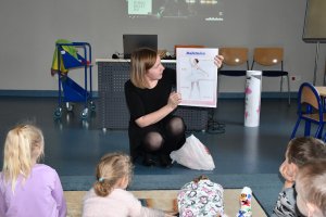 Na zdjęciu powadzaca zajęcia bibliotekarka z dziećmi.