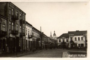 czarnobiała pocztówka na której widać ludzi zajętych codziennymi sprawami